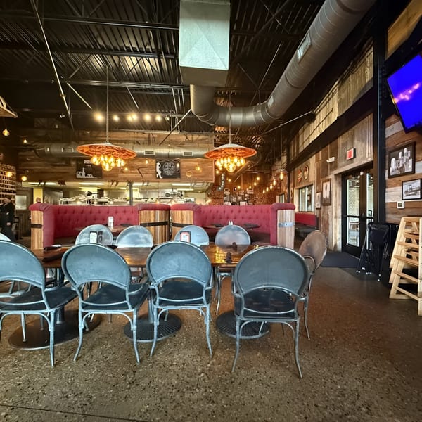 Interior of Drake's Yoke BBQ restaurant with red booths, wooden tables, and industrial-style lighting.