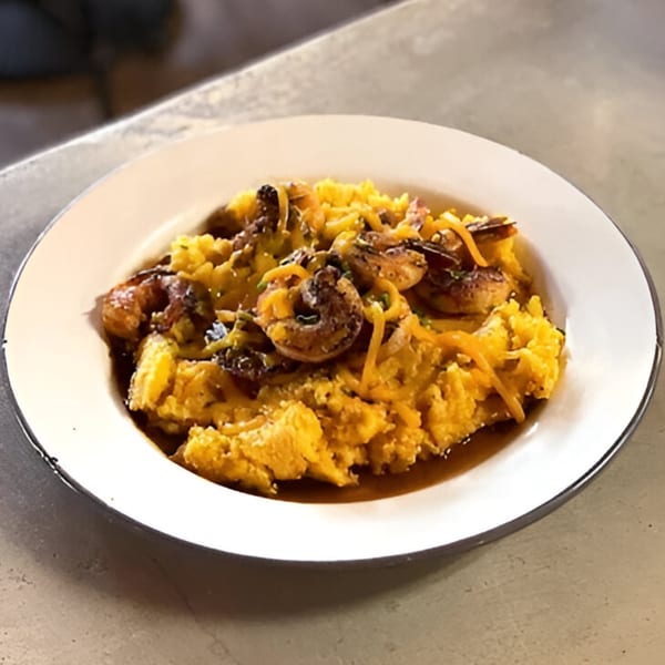 Drake's Yoke's shrimp and grits, topped with shredded cheese and a rich sauce.