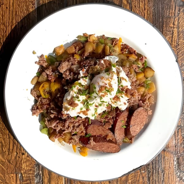 Drake's Yoke BBQ hash with pulled pork, sausage, potatoes, peppers, and a dollop of sour cream.